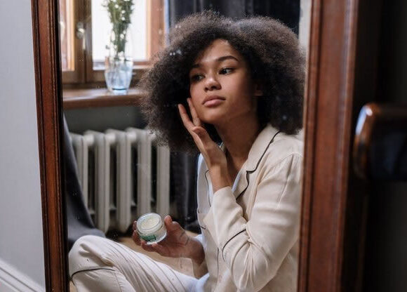 Young lady applying nightime PM Skin Care Routine for Fungal Acne